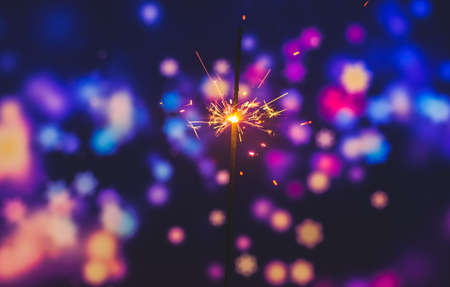 Photos on a bright blue purple background with sparklers festive lights holiday and Christmas and New Year on the desktop or banner on the websiteの写真素材
