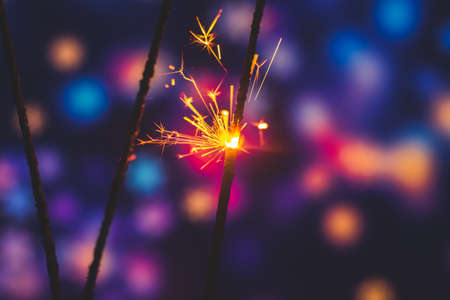 Photos on a bright blue purple background with sparklers festive lights holiday and Christmas and New Year on the desktop or banner on the websiteの写真素材