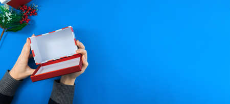 New Year series of photos on a blue background with the hands of a girl and a man with cozy objects, with books and postcards, Christmas and wishesの写真素材