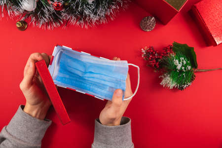 A series of New Year's photos on a beautiful red background on the theme of the COVID virus, take care of yourself, masks in the photo, gifts for Christmasの写真素材