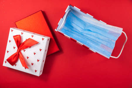 A series of New Year's photos on a beautiful red background on the theme of the COVID virus, take care of yourself, masks in the photo, gifts for Christmasの写真素材