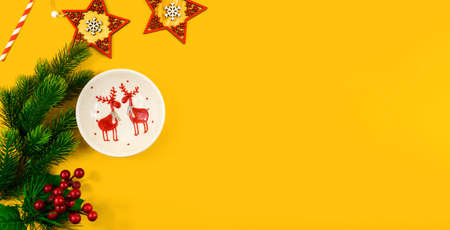 A series of beautiful conceptual photographs on a yellow and orange background for a christmas and new year etmu, pine cones, fir branches, top view, templates and banners with gifts and a notebookの写真素材
