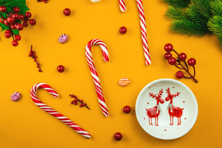 A series of pre-christmas photos on a red and yellow background with lollipops and attributes of the holiday, top view, flat designの写真素材