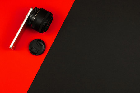 Composition of a smartphone with a lens from a DSLR, comparison of cameras, copy space, flat background photoの写真素材