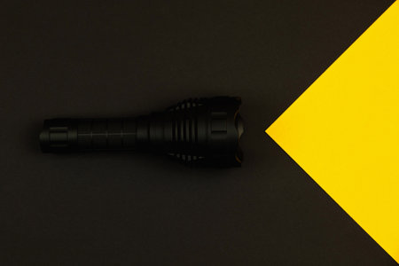 Flashlight shines concept, flat lay design, copy space, black background photoの写真素材