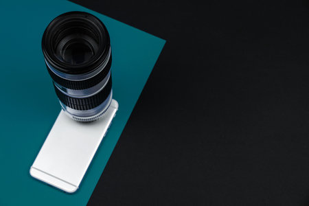 Modern concept, smartphone camera capabilities, DSLR telephoto lens, tidewater green background, copy space banner photoの写真素材