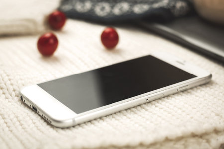 Business flat lay concept, composition with winter warm knitted sweaters, decoration and blank smartphone, copy space photoの写真素材