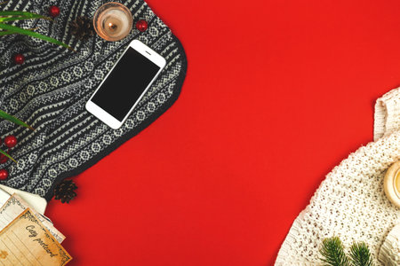 Cozy workspace, winter flat lay and hygge design with copy space, knitted sweaters, smartphone, postcard, pine cones and decorations photoの写真素材