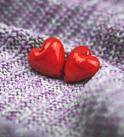Bright Valentine's Day background, two red hearts, couple love concept, square, purple knitted sweater photoの写真素材