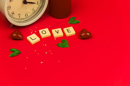 Trendy Valentine's Day background on red with love word on cubes and decorations, copy space photoの写真素材