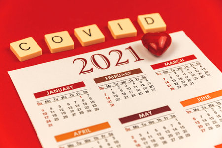 Valentine's Day COVID-19 composition with calendar and inscription lettering, one red heart and red background, photoの写真素材