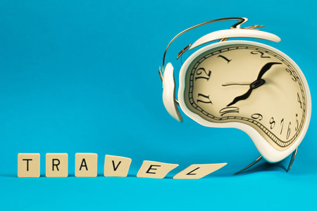 Alarm clock is distorted, travel concept during pandemic, composition with word on blue isolated background, copy spaceの写真素材
