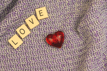 Valentine's Day simple composition on knitted background, love word and red heart. High quality photoの写真素材