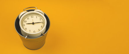 Take care about yout time concept, alarm clock in trash bin banner, flat lay copy space. High quality photoの写真素材