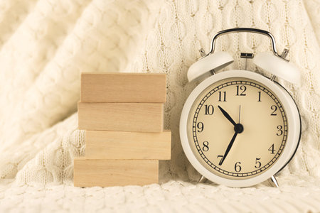 Wooden pegs and blocks with place for text, cozy morning concept background or template with alarm...
