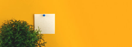 Mockup with black paper note pinned at yellow background wall, minimal workspace banner with a...