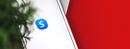 Kharkov, Ukraine - 26 January, 2021: Skype application on the screen of Apple iPhone smartphone, flat lay banner, copy space photoのeditorial素材