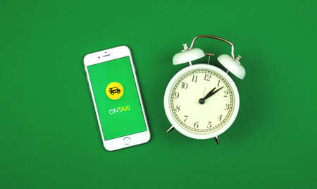 Kharkov, Ukraine - February 5, 2021: OnTaxi service application icon and on Apple smartphone screen, creative flat lay background and banner photoのeditorial素材