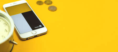 Kharkov, Ukraine - February 5, 2021: Yandex Go Taxi app on Apple smartphone, delivery service flat lay banner background, copy space and money conept photoのeditorial素材