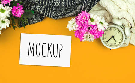 Spring greeting card mockup, cozy office or home workspace with flowers, holiday and festive composition on orange backgroundの写真素材