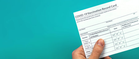 Doctor is holding COVID-19 vaccination record card, banner, concept of healthcare, copy space photo