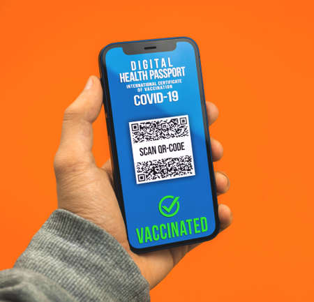 Man holds smartphone with health passport application, valid COVID-19 test resultの写真素材