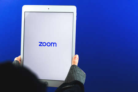 Kharkov, Ukraine - February 28, 2021: Zoom Cloud Meeting logo on Apple iPad screen in woman hand, banner, copy space photoのeditorial素材