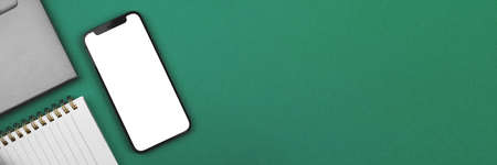 Office desktop with mockup, mobile phone with blank white screen, banner with copy spaceの写真素材