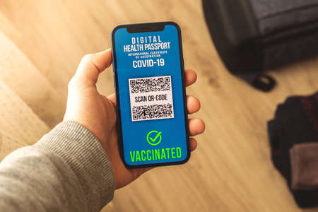 Health passport digital app on the screen, person is using application for checking vaccination in airport before travelの写真素材