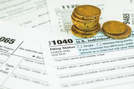 US individual income 1040 tax form, babckground with stack of coinsの写真素材