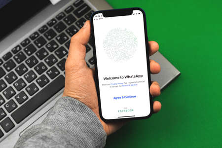 Kharkov, Ukraine - March 9, 2021: Man using Whatsapp application, title screen of the app for messagingのeditorial素材