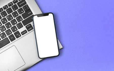 Business and financial mockup with modern smartphone on laptop, office desk and workspace photo
