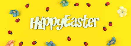 Happy Easter spring background, baner with ladybug and flowers on yellow paperの写真素材
