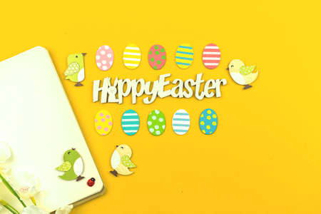 Happy Easter workspace background with text message and easter decoration, painted eggs and flat lay design photoの写真素材