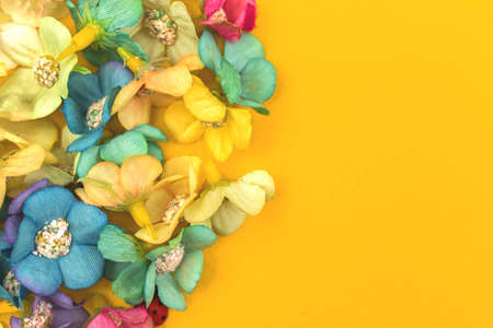 Spring floral background with colorful flowers on a yellow paperの写真素材