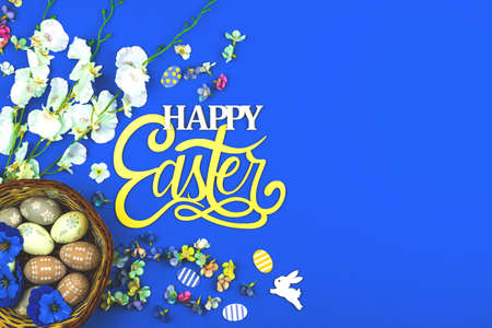 Happy Easter background with egg nests and spring flower, blue background and top view photoの写真素材