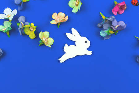 Easter bunny background, flat lay composition with spring flowers on blue backgroundの写真素材
