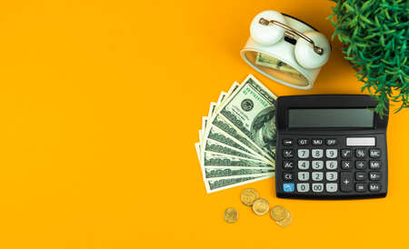 Business workspace, office table with calculator and money, alarm clock, copy space photoの写真素材