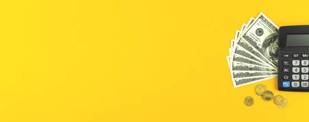 Calculator and money banner, financial concept, yellow background and copy space photoの写真素材