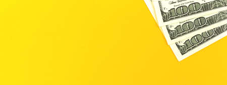Banner with stack of one hundred US bills, yellow background, copy space photoの写真素材