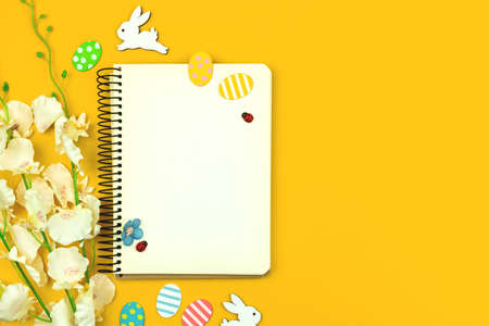 Spring mockup with easter decor on a yellow background, top view and copy space photoの写真素材