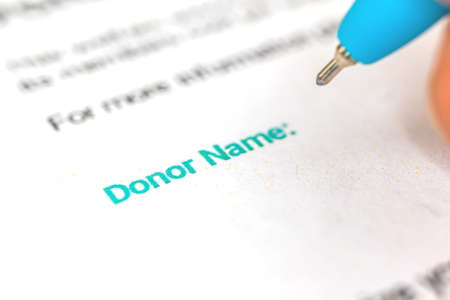 Donation form with donor name background, man is signature donation consent, charity concept photoの写真素材
