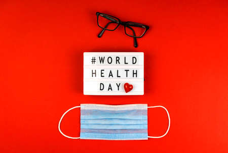 World health day concept background with text message, medical mask and one red heartの写真素材