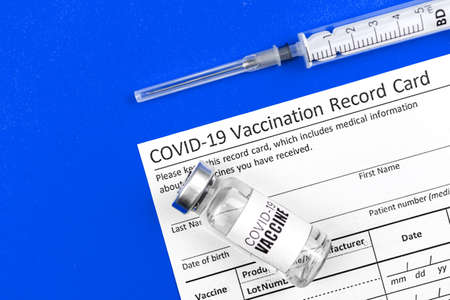 COVID-19 vacciation record card official document background, top view, hospital photoの写真素材