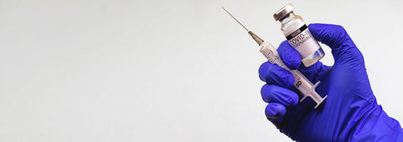 Vaccination banner, doctor hand in gloves holds COVID-19 vaccine vial and medical syringe,...