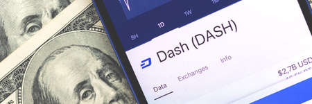 DASH cryptocurrency on the screen, smartphone for stock trading and buying coins, US dollars on the background photoの写真素材