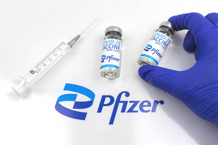Kharkov, Ukraine - April 18, 2021: Doctor in blue gloves hold Pfizer Coronavirus COVID-19 vaccine...