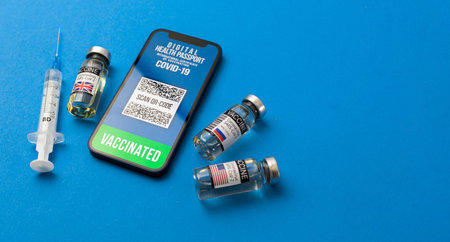 Go get vaccination concept, smartphone with digital vaccine passport, with vaccine vials and syringe...
