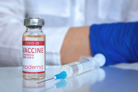 Kharkov, Ukraine - April 19, 2021: Moderna COVID-19 vaccine vial close up on doctor tableのeditorial素材