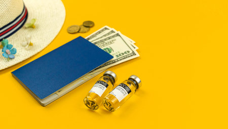 Safe travel after vaccination, summer vacation concept, yellow background with passport and money,...